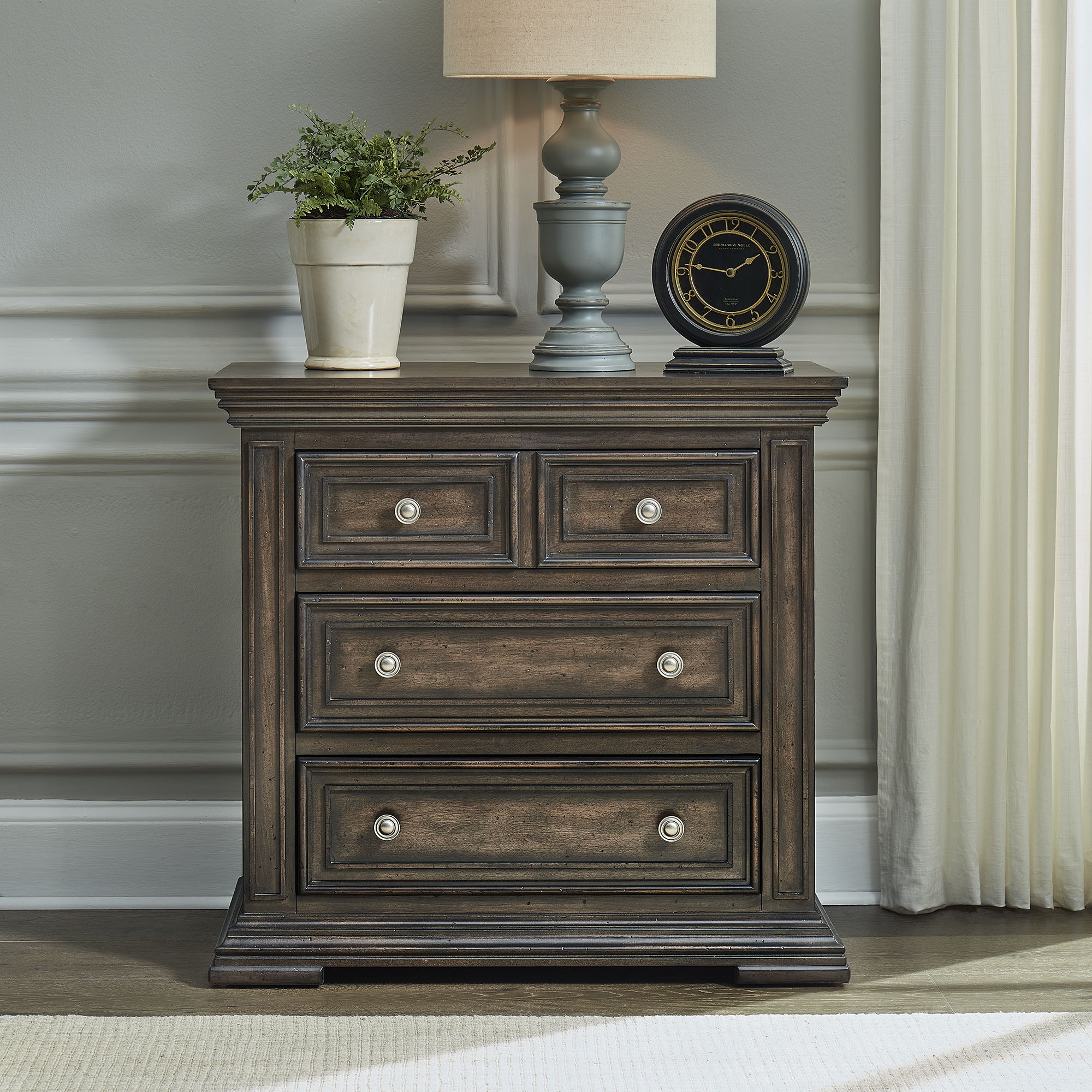 Commode de chevet avec station de recharge — Les façades de tiroir encadrées de bois et les pieds blocs complètent ce look traditionnel.